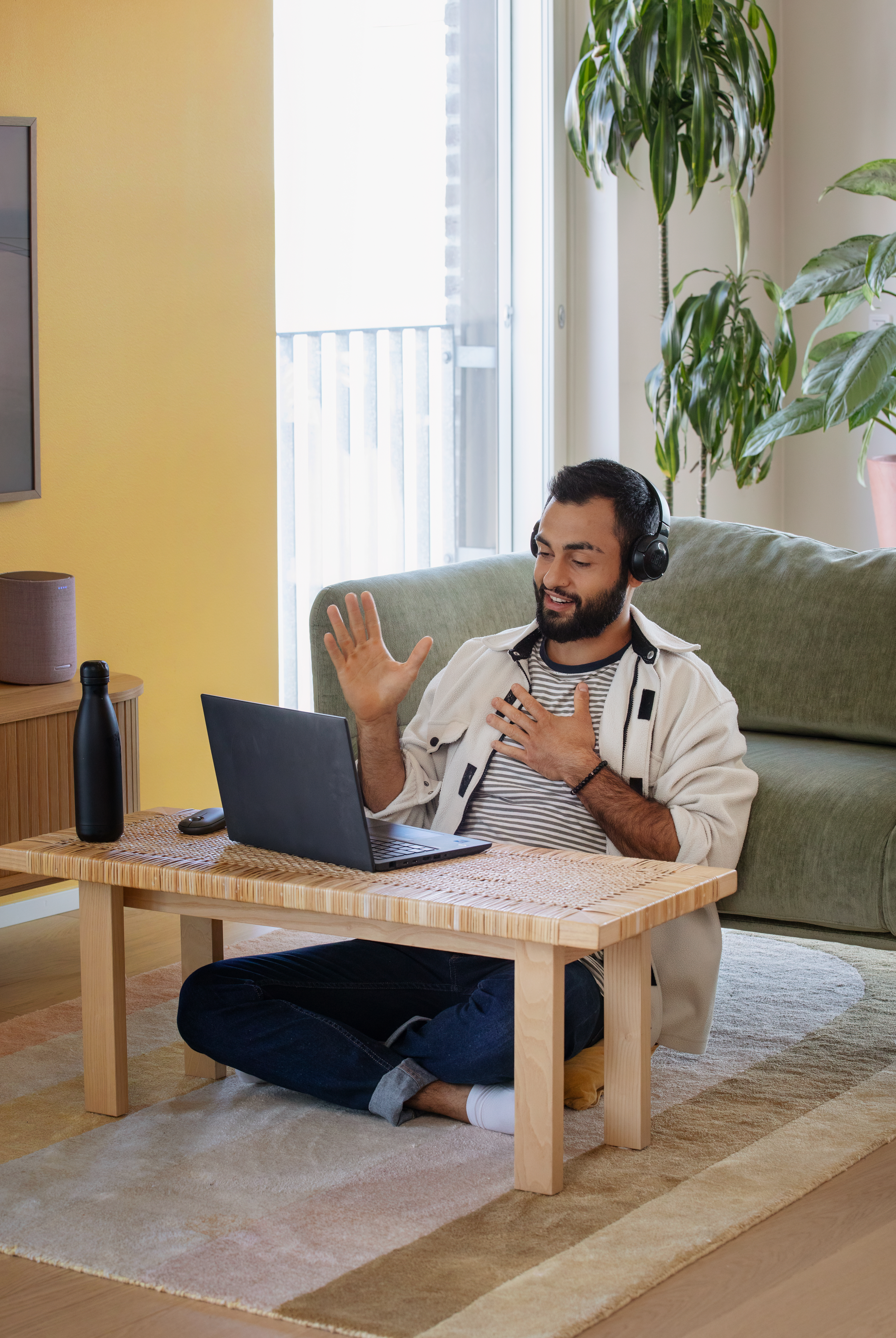 Man sitting by a sofa working
